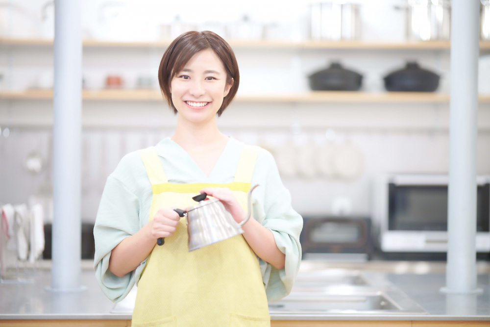 排水口にかけるお湯を持つ女性のイメージ画像