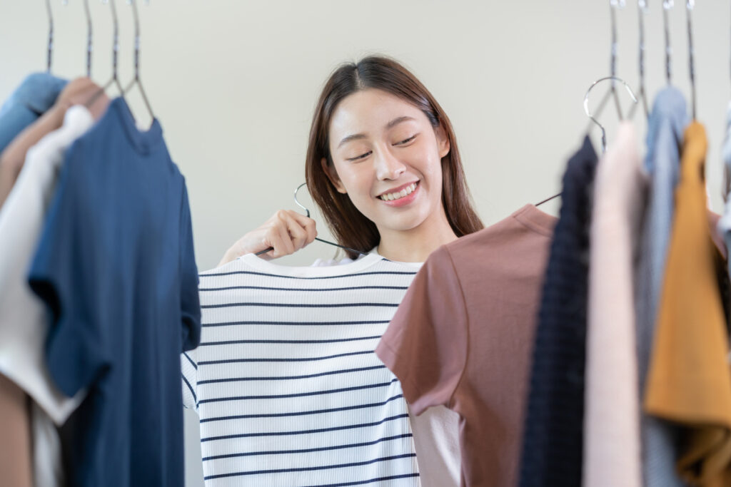 ウォークインクローゼットで洋服を選ぶ女性